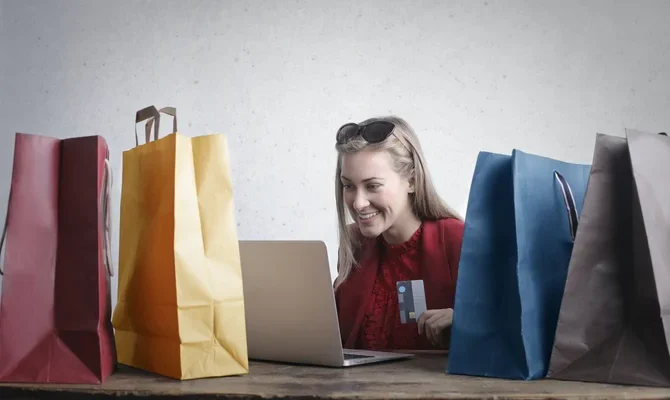 Frau mit Shopping Tüten sieht sich Produktvideos an