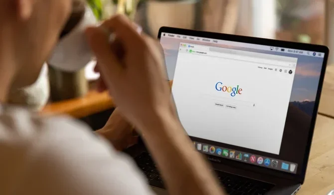 Mann sitzt vor Laptop mit Google offen